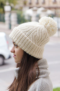 white cream cozy and warm chunky cable knit hat with a big yarn pompom