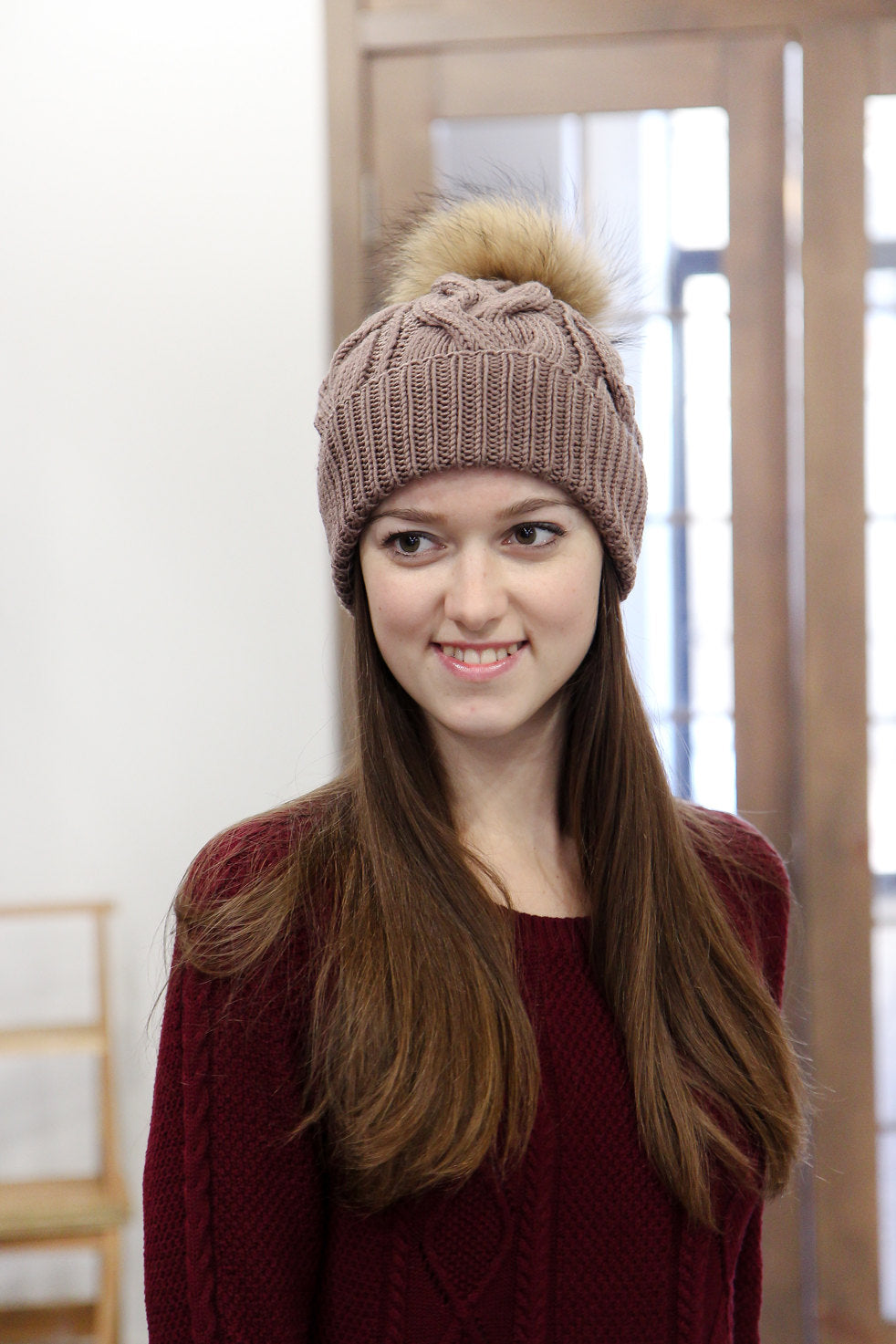 brown hand knitted hat with fur pom pom
